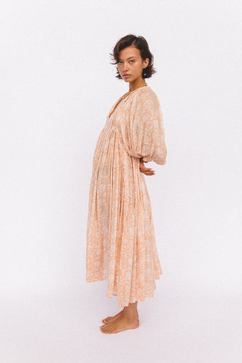 Daughters of India Kyra Midi Dress in Apricot Blush — studio side profile, billowed sleeves and gathered waist, hand screen print cotton