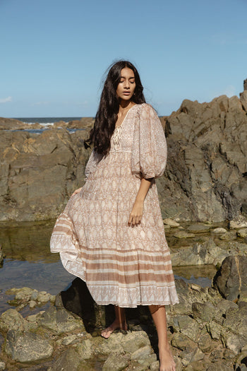 Daughters of India Jasmine Midi Dress in Shell — full length on rocky shore, hand screen print cotton with balloon sleeves