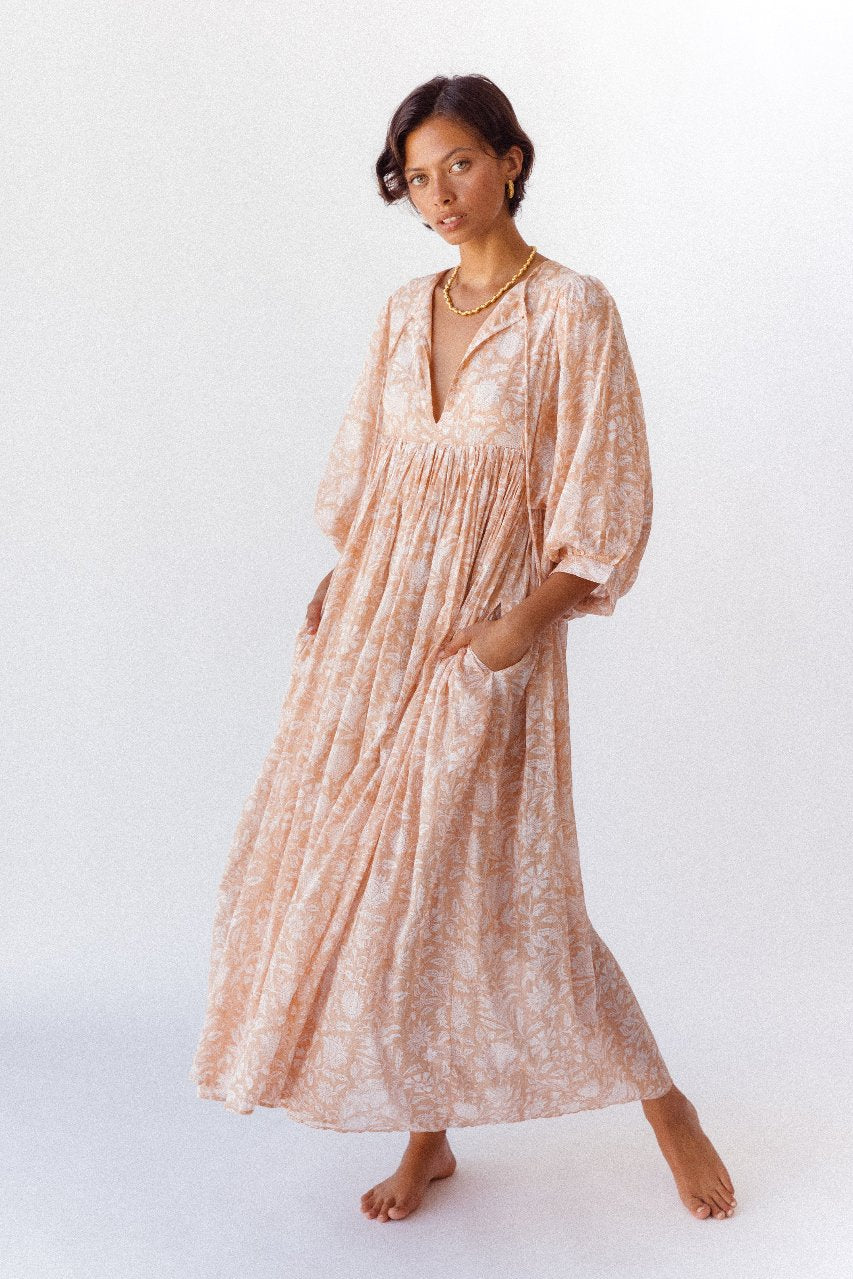 Daughters of India Kyra Maxi Dress in Apricot Blush — studio three-quarter view hand in pocket, billowed sleeves