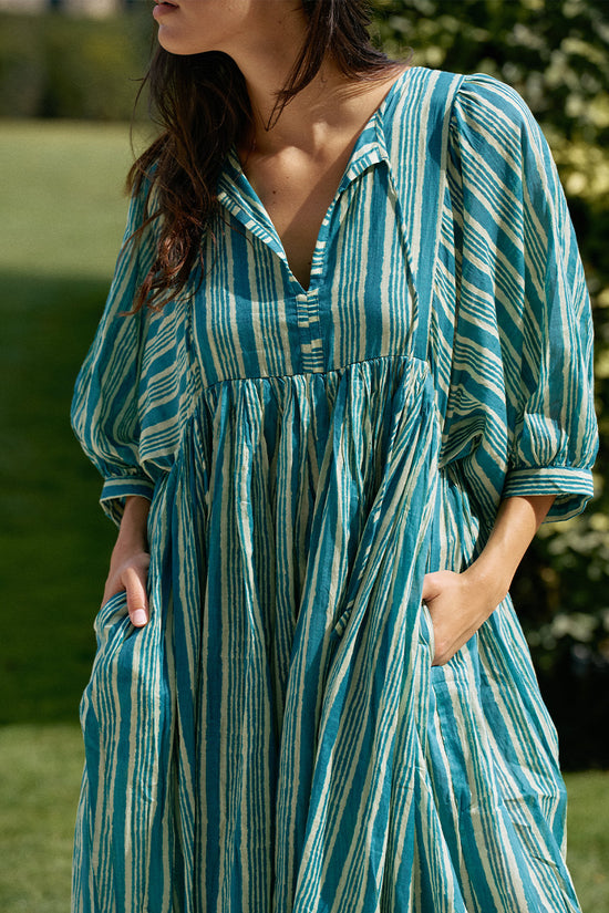 Close-up of woman outdoors wearing the Daughters of India Kyra Midi Dress in Spearmint, showing hands in hidden pockets and the relaxed V-neckline