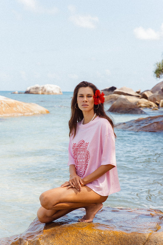 Shanti Tee Pink — back view at beach, pink oversized cotton tee showing clean back and oversized fit, ocean and rocks backdrop | Daughters of India